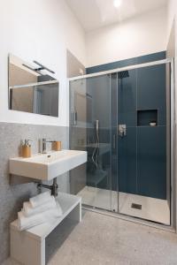 uma casa de banho com uma cabina de duche em vidro e um lavatório. em Nimar Suite em Formia