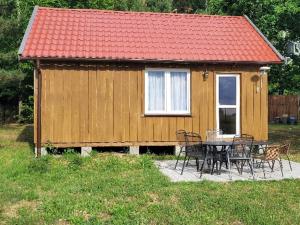 a house with a table and chairs in front of it at Domek letniskowy LUNA in Barczewo