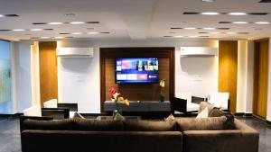 グルガオンにあるAVA Hotels and Corporate Suitesのソファと薄型テレビ付きのロビー