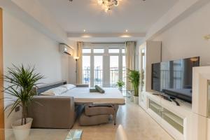 a living room with a table and a couch and a tv at Charming 3 Bedroom Apartment at Triana Center By Oui Seville in Seville