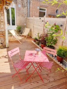 a pink table and two chairs on a patio at Lam'Bray in Forges-les-Eaux