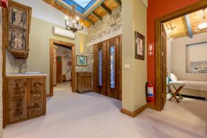 a hallway with wooden doors and a stone wall at Sakin Ev in Alacati