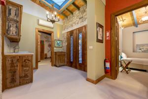 a hallway with wooden doors and a stone wall at Sakin Ev in Alaçatı