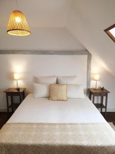 a bedroom with a white bed with two side tables at Lam'Bray in Forges-les-Eaux