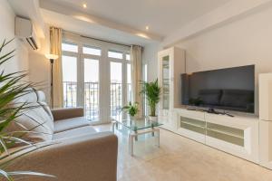 a living room with a couch and a tv at Charming 3 Bedroom Apartment at Triana Center By Oui Seville in Seville
