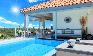 a villa with a swimming pool and a patio at Olive Green Villa Heated Pool in Agios Nikolaos