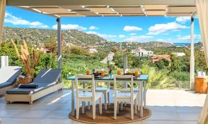 a table and chairs on a patio with a view at Olive Green Villa Heated Pool in Agios Nikolaos