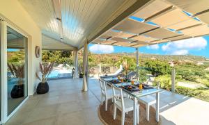 an open patio with a table and chairs on it at Olive Green Villa Heated Pool in Agios Nikolaos