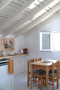eine Küche mit einem Holztisch und Stühlen im Zimmer in der Unterkunft Katelios Farm House Loft in Kateliós