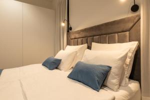 białe łóżko z dwoma niebieskimi poduszkami w obiekcie Villa Excellente w mieście Mandre