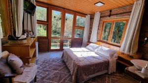 a bedroom with a bed in a room with windows at Villa Italia hospedagem in Gramado