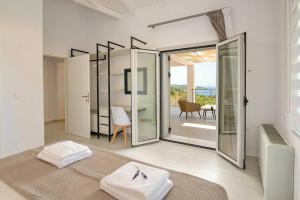 ガイオスにあるTania Villa by PaxosRetreatsのベッド1台、ガラスのスライドドアが備わる客室です。