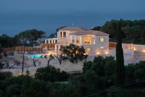 a large white house with a pool in front of it at Tania Villa by PaxosRetreats in Gaios