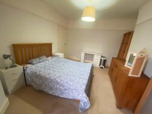 1 dormitorio con 1 cama, vestidor y TV en Nharakat Mansion, en Southampton