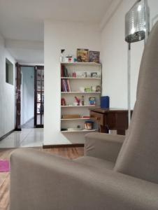 a living room with a couch and a book shelf at APARTAMENTO BARRA DO JUCU VISTA MAR in Vila Velha