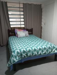 a bed with a green comforter in a room at APARTAMENTO BARRA DO JUCU VISTA MAR in Vila Velha +16 photos