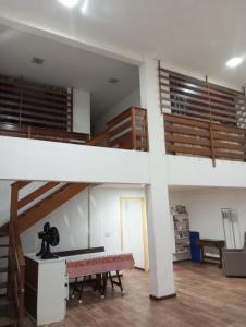a living room with a staircase and a table at APARTAMENTO BARRA DO JUCU VISTA MAR in Vila Velha