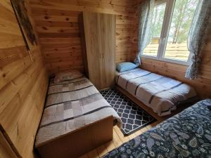 1 dormitorio con 2 camas en una cabaña de madera en Domek letniskowy LUNA, en Barczewo