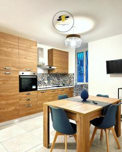 cocina con mesa de madera y sillas azules en Casa Cicerone Lucrino, en Pozzuoli