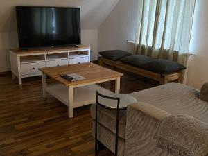 a living room with a tv and a coffee table at Ferienwohnung mit großer Dachterrasse in Bielefeld