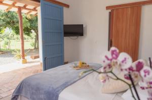 a room with a blue door and a table with flowers at Trinitarios in Barichara
