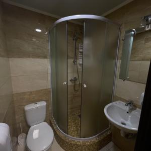 a bathroom with a shower and a toilet and a sink at Nirvana in Rivne