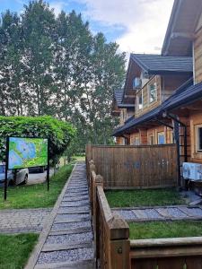 uma casa com uma cerca de madeira ao lado de uma casa em Skansen Holiday em Cholerzyn