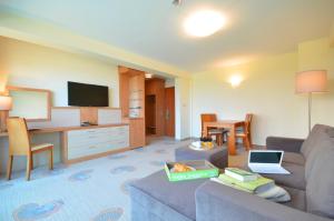 a living room with a couch and a table with a laptop at Hotel Hanseatic - Adults Only in Kołobrzeg