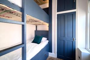 a bedroom with a bunk bed with a blue door at Marina Bridge House Central Cowes in Cowes