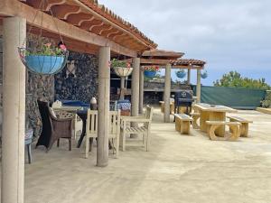 patio ze stołem i krzesłami oraz stołem i ławkami w obiekcie TENERIFE ECOLIFE HOUSES by APARTAMENTOS ESTRELLA DEL NORTE w mieście Garachico