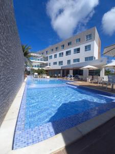 uma grande piscina em frente a um edifício em Vivenda dos Corais em Porto de Galinhas