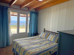 a bedroom with a bed with a view of the ocean at TENERIFE ECOLIFE HOUSES by APARTAMENTOS ESTRELLA DEL NORTE in Garachico