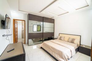 a bedroom with a bed and a desk in it at TERANGA IMMO LUXE in Dakar