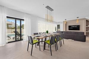 a dining room with a table and chairs and a couch at Seaside Villa Bamboo - Fažana in Fažana