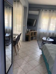 a living room with a table and a tv at Maria's Central Apartment in Igoumenitsa