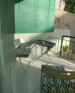 uma mesa e duas cadeiras sentadas numa varanda em Maria's Apartment! em Igoumenitsa