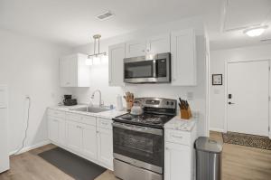 a white kitchen with a stove and a microwave at Halifax Inn in Halifax
