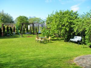 a garden with a table and chairs and a swing at Jūra in Ventspils