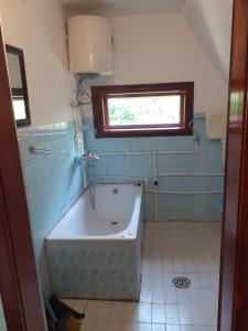 a bathroom with a bath tub and a window at Apartman Vidikovac in Varna