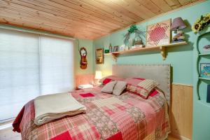 um quarto com uma cama com um cobertor xadrez em Lakefront Backus Cabin with Gazebo and Gas Grill! 