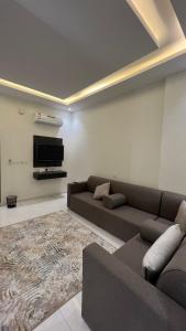 ein Wohnzimmer mit einem Sofa und einem TV in der Unterkunft شقق ميسم الورد للشقق المفروشه in Mahlal