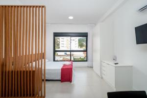 a bedroom with a bed and a window at Studio para casais bem localizado ARE504 in Florianópolis