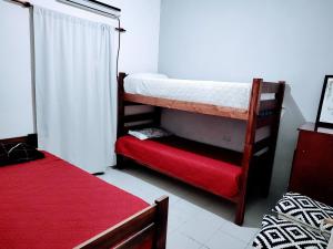 um quarto com 2 beliches e um colchão vermelho em C & J Casa de alquiler em Maco