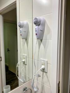 a bathroom with a mirror and a blow dryer on the wall at Departamentos Premium - Boero Rentals in Belén de Escobar