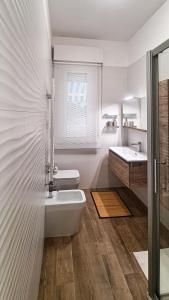 a white bathroom with a toilet and a sink at casapepa in Ancona