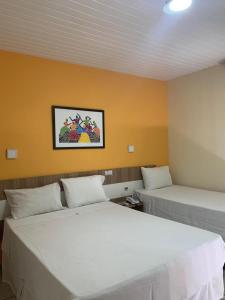 2 łóżka w pokoju z żółtymi ścianami w obiekcie Boulevard Park Hotel w mieście São Luís