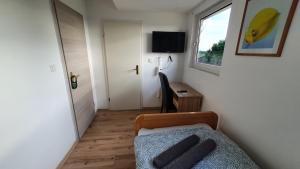 1 dormitorio con cama, ventana y escritorio en GreyGreen Residence I - Privates Bad, Gemeinschaftsküche und Aufenthaltsbereich, en Sehnde