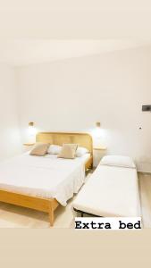 Duas camas num quarto com paredes brancas em CASA SACURI em Rudalza