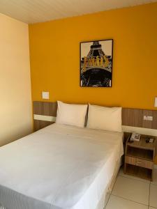 łóżko w pokoju z żółtą ścianą w obiekcie Boulevard Park Hotel w mieście São Luís