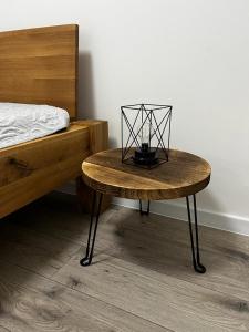 a wooden table with a lamp on it next to a bed at Urban ZION apartment in Liptovský Mikuláš